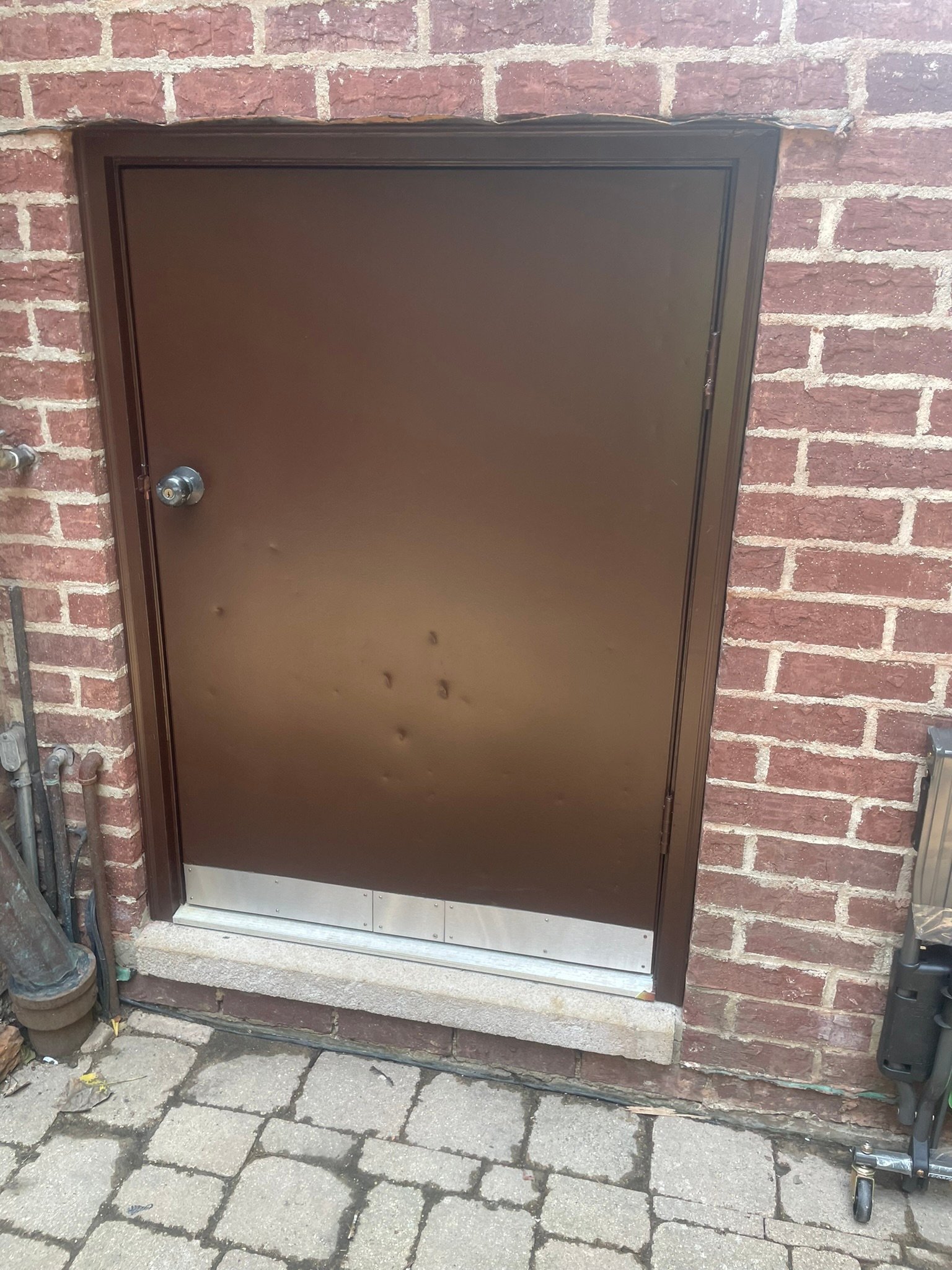 Exterior door with new kick plates and fresh weatherproofing before an Illinois winter