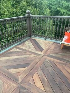 Restored Ipe deck with diagonal X pattern decking and ornate railing after restoration