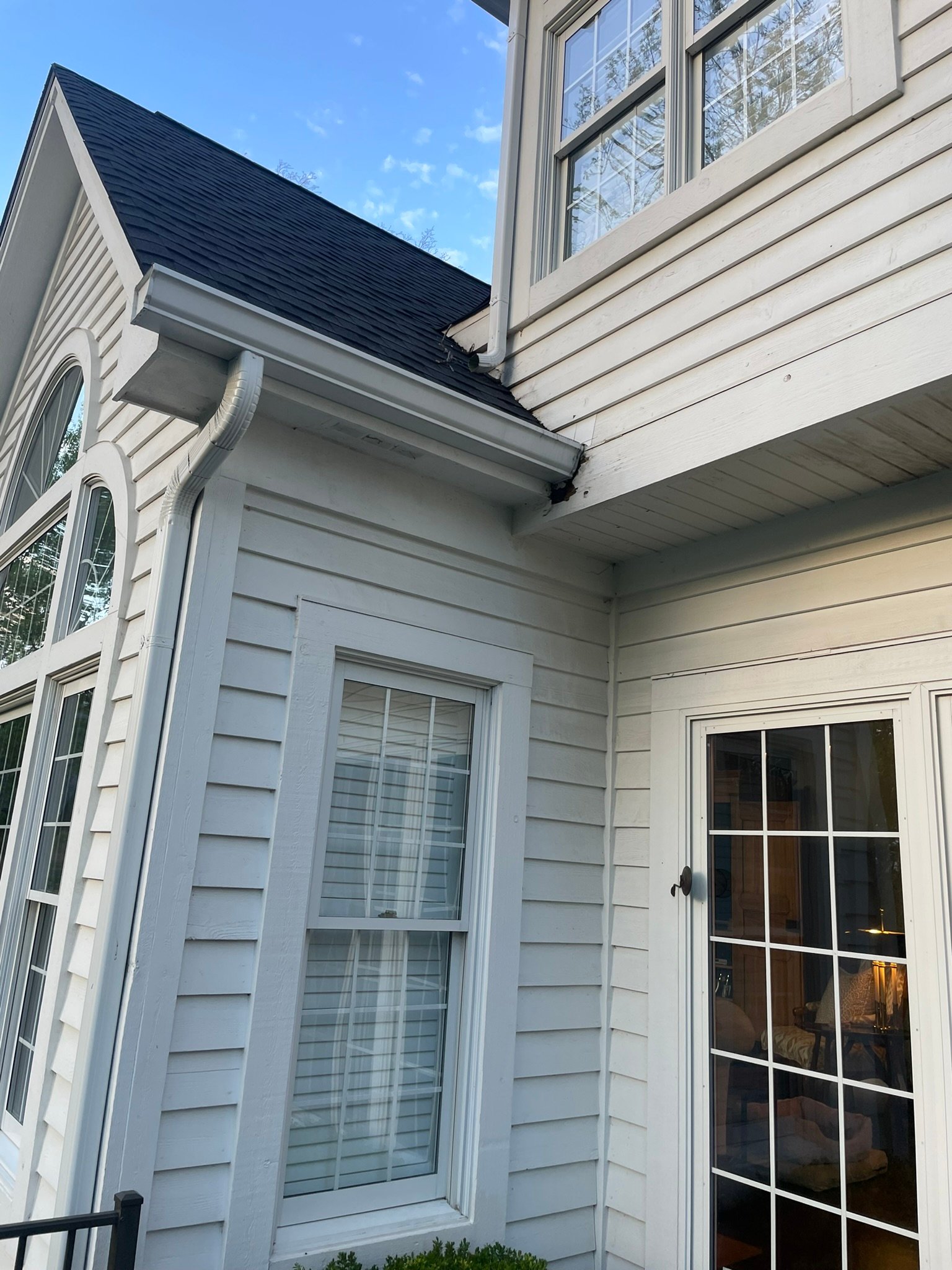 Rotted soffit corner near a gutter after winters of overflow, before repair in Lake County IL