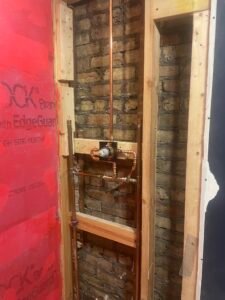 New copper shower valve rough-in plumbing during a permitted bathroom remodel in Mundelein IL