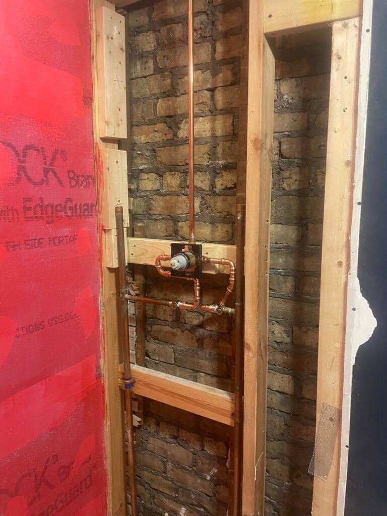 New copper shower valve rough-in plumbing during a permitted bathroom remodel in Mundelein IL