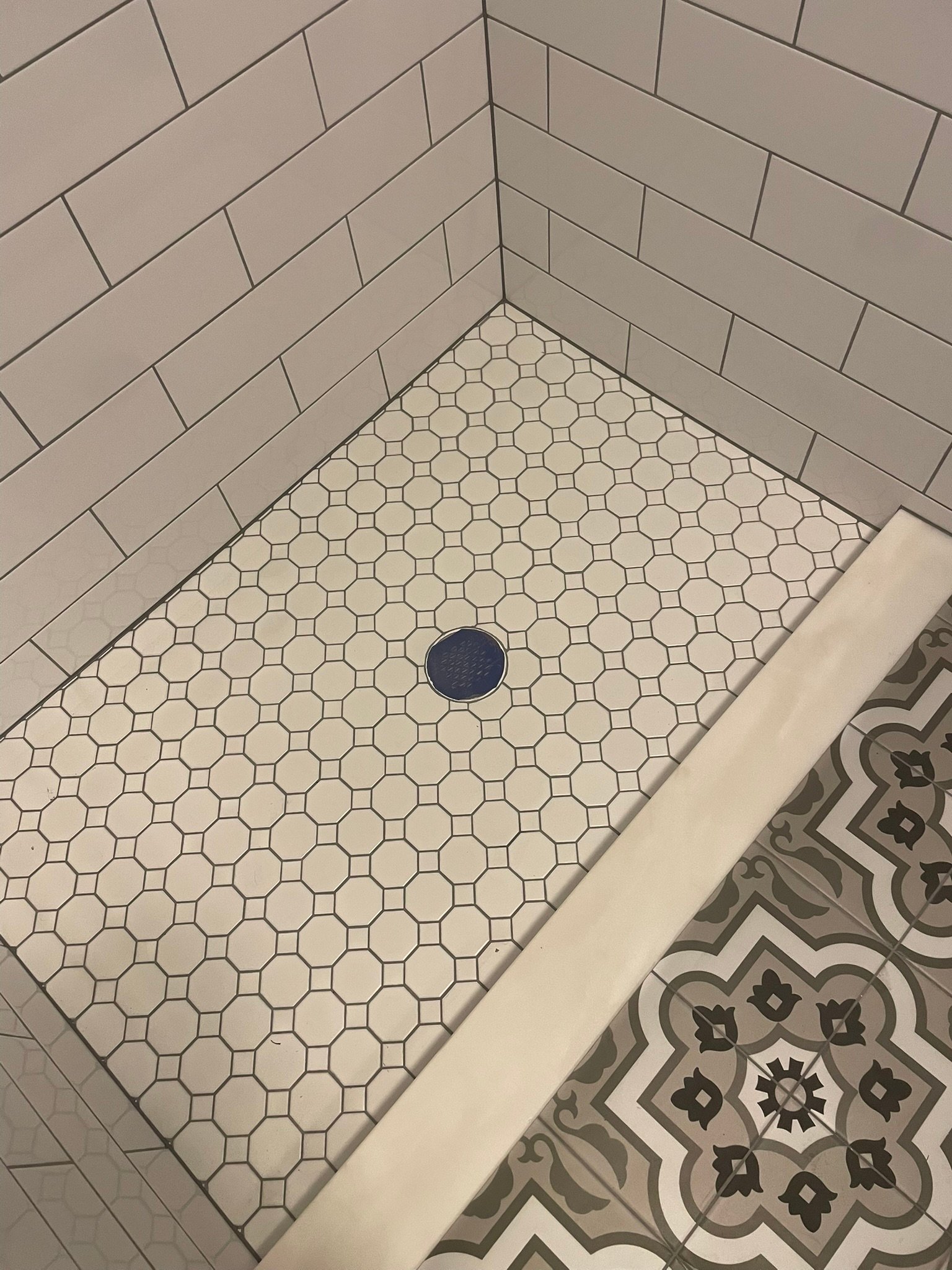 Finished shower pan with octagon dot mosaic and marble curb from a shower remodel in Mundelein IL