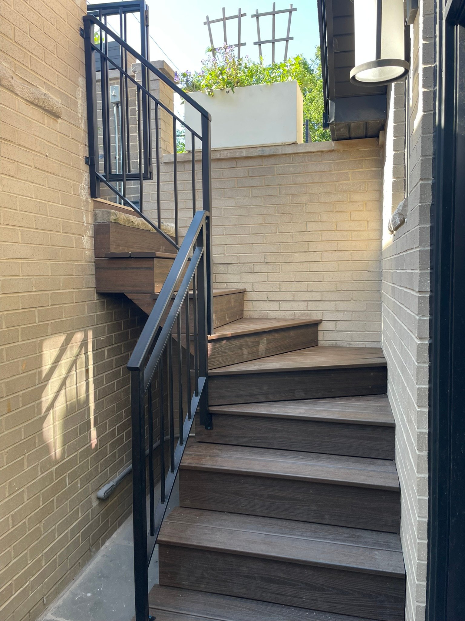 Completed composite deck stairs with black metal railing after a deck rebuild in Waukegan IL